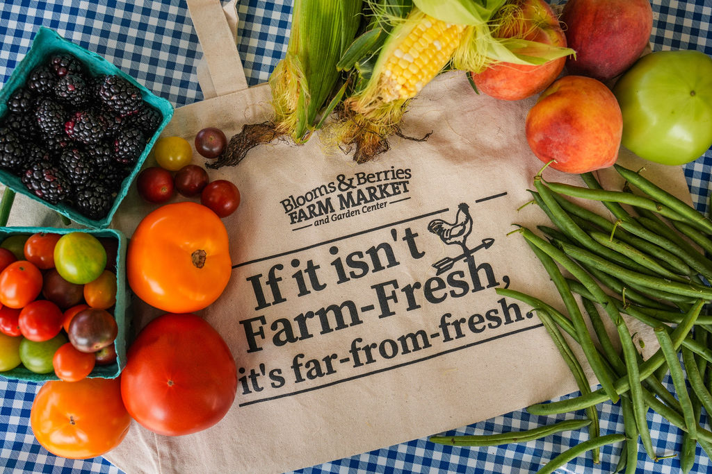 produce bag with produce an array of fresh fruit and veggies on top of a canvas tote bag